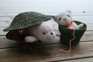 Tøjdyr i hver sin kurv. Katten med legegarnnøgle og perlehalsbånd.